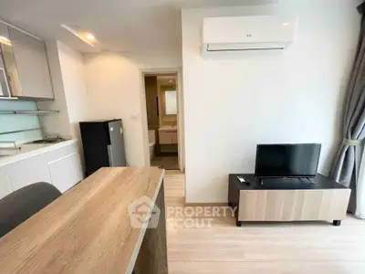 Modern studio apartment with kitchenette and living area, featuring sleek design and natural light.