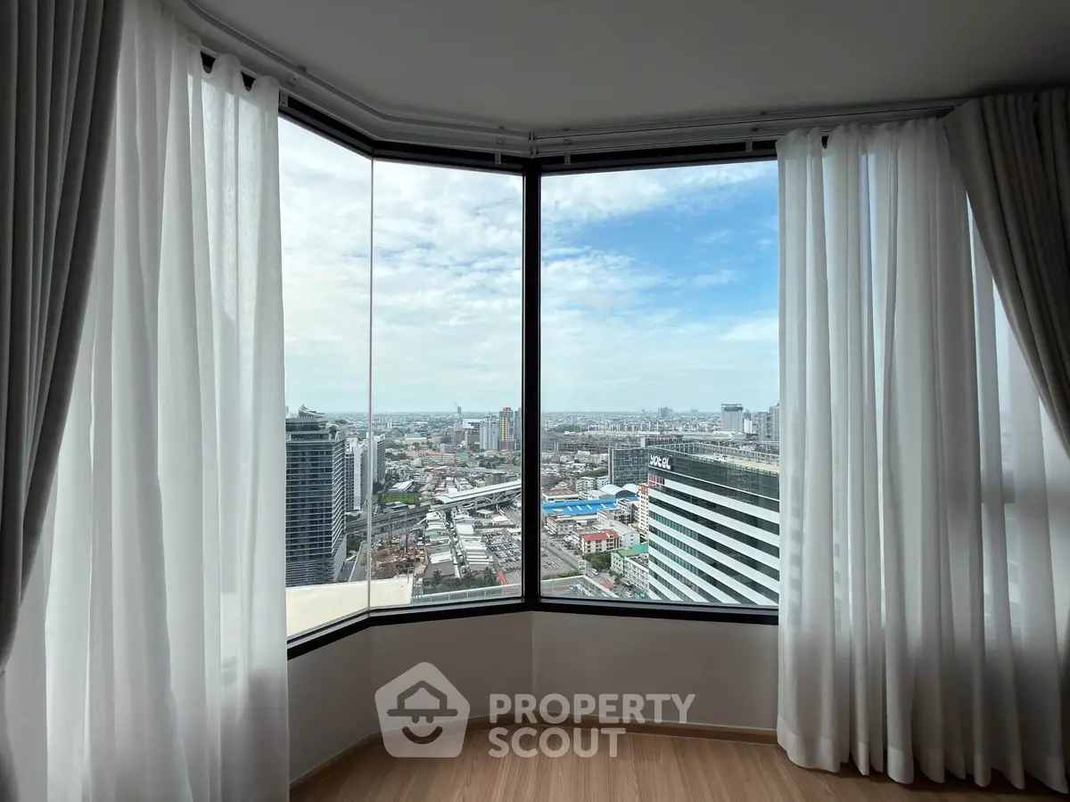 Stunning corner unit with panoramic city view through large windows and elegant curtains.