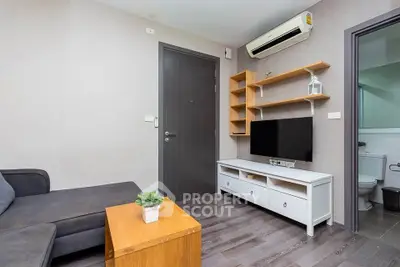 Modern living room with sleek furniture and air conditioning, featuring a cozy sofa and stylish TV unit.