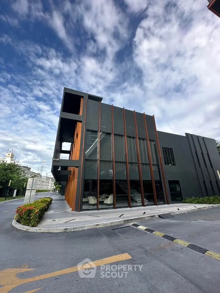 Modern commercial building with sleek design and large windows under a vibrant sky.