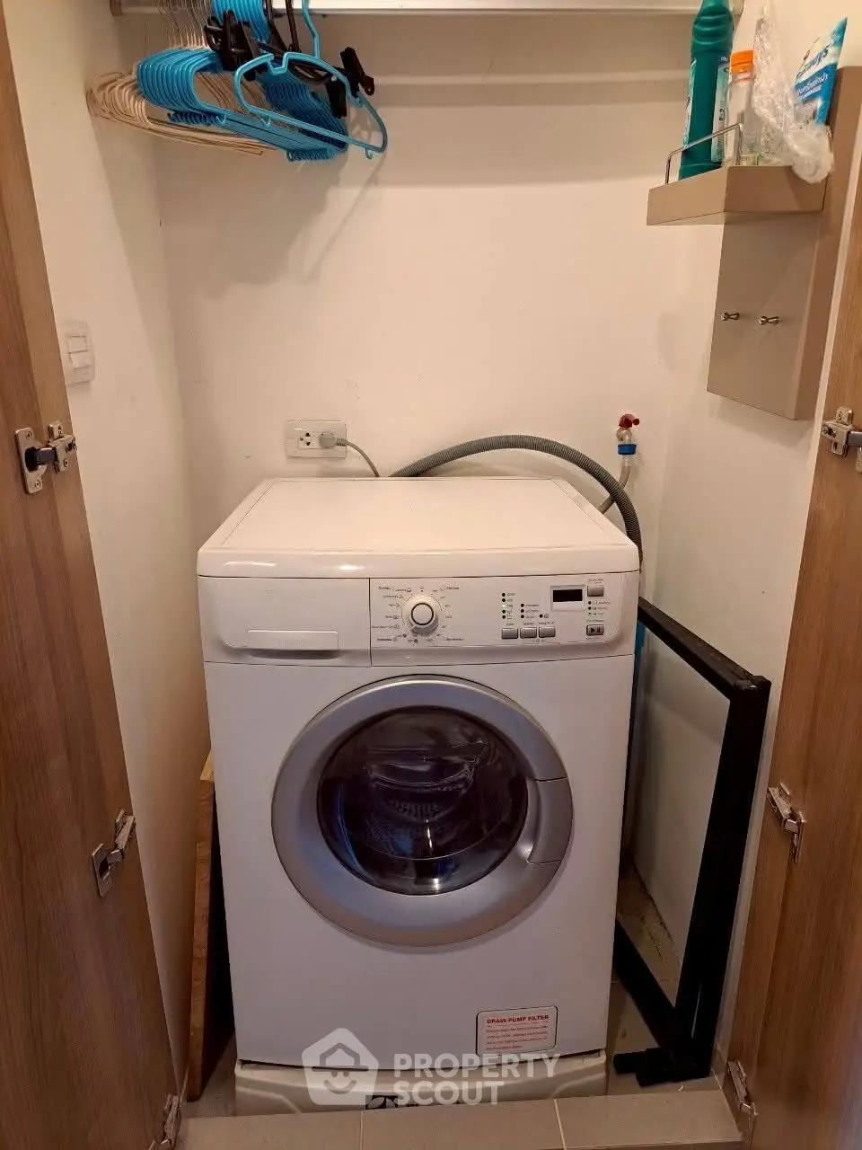 Compact laundry area with washing machine and storage shelves