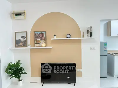 Modern living room with stylish decor and wall-mounted shelves, featuring a sleek TV and contemporary design.