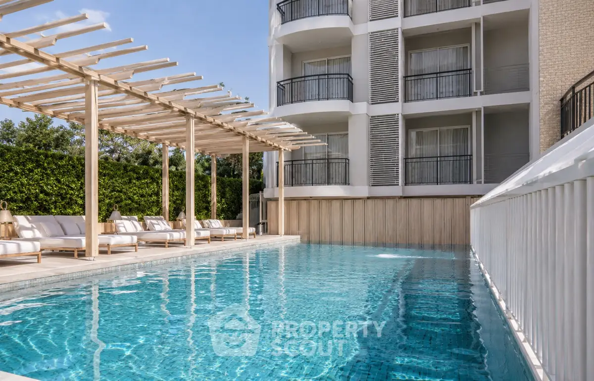 Luxurious apartment building with stunning outdoor pool and elegant lounge area.