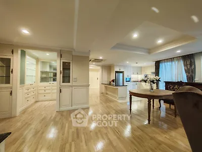 Spacious open-plan living and dining area with elegant wooden flooring and modern lighting.