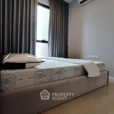 Modern bedroom with stylish decor and natural light, featuring a comfortable bed and elegant curtains.