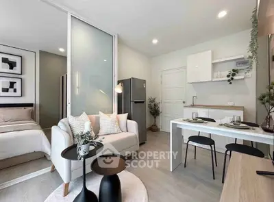 Modern open-plan living room and kitchen with stylish decor and cozy bedroom view.