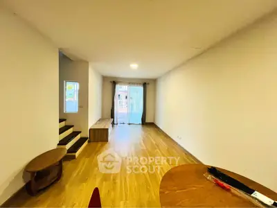 Spacious living room with wooden flooring and natural light, perfect for modern living.