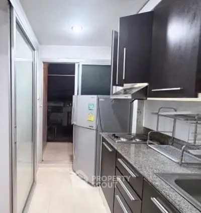 Modern kitchen with sleek cabinets and stainless steel appliances in a compact layout.