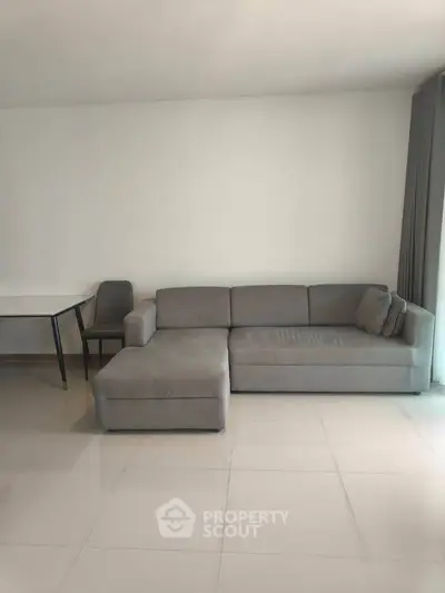 Spacious living room with modern gray sofa and natural light