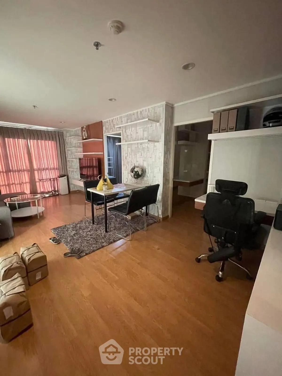 Spacious living room with modern decor and wooden flooring, featuring a cozy study corner.