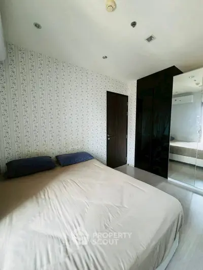 Cozy bedroom with modern decor and mirrored wardrobe in stylish apartment.