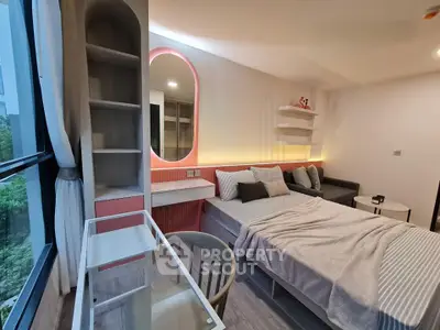 Modern bedroom with stylish decor, large window, and cozy seating area in a contemporary apartment.