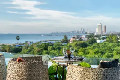 Stunning balcony view overlooking city skyline and ocean, perfect for outdoor dining.