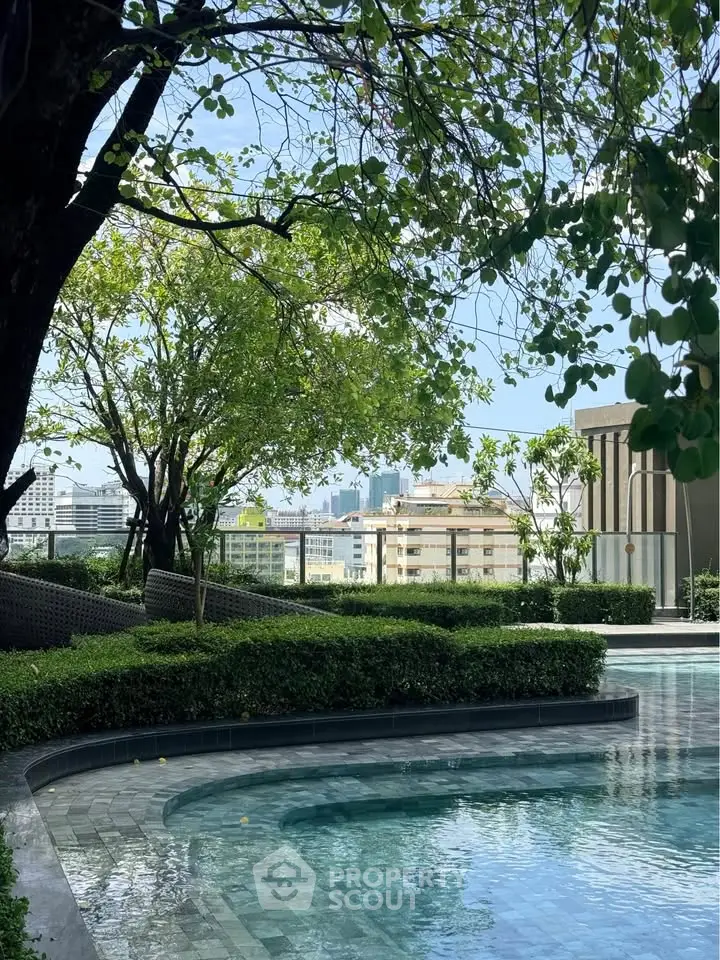 Luxurious rooftop pool with lush greenery and city skyline view, perfect for relaxation and leisure.