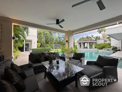 Luxurious outdoor living area with poolside view and elegant furniture