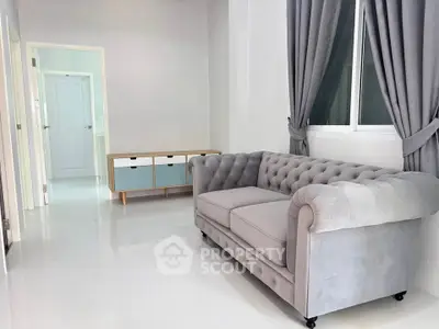 Elegant living room with plush gray sofa and modern decor in bright, airy space.