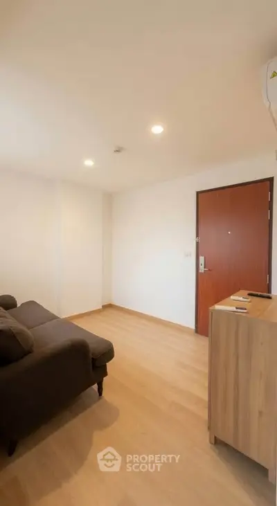 Cozy living room with wooden flooring and modern furniture in a minimalist apartment.