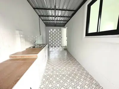 Spacious kitchen with tiled floor and modern fixtures in a bright, airy setting.