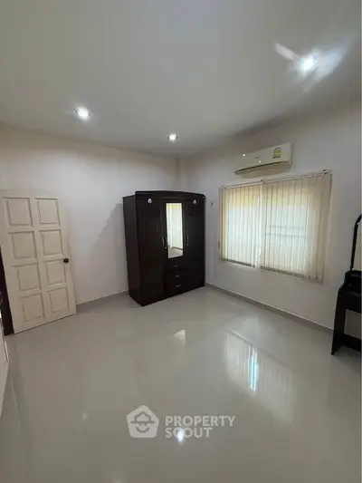 Spacious bedroom with modern wardrobe and air conditioning, perfect for comfortable living.
