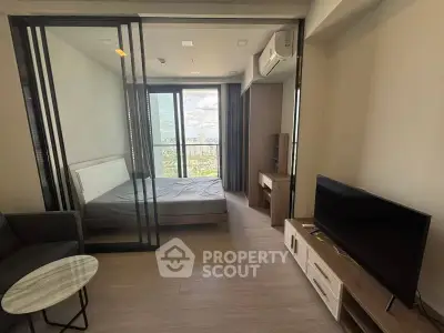 Modern studio apartment with glass partition and city view, featuring sleek furniture and natural light.