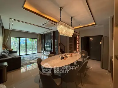 Luxurious open-plan living and dining area with elegant chandelier and modern furnishings.