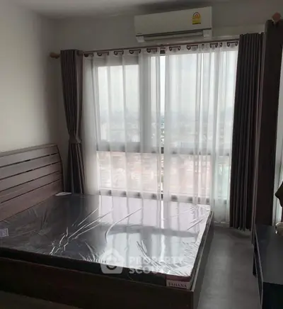 Modern bedroom with large window and city view, featuring a sleek wooden bed frame and neutral decor.