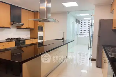 Modern kitchen with sleek black countertops and built-in appliances in a spacious apartment.