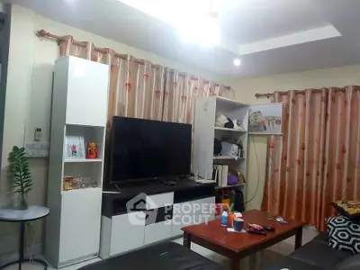 Cozy living room with modern TV setup and stylish curtains