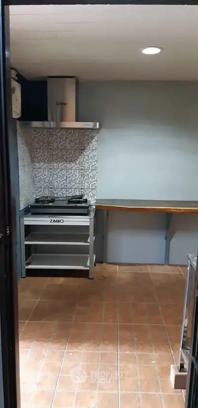 Modern kitchen with gas stove and tiled backsplash, featuring a sleek design and efficient layout.