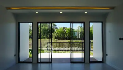 Spacious living room with large glass doors opening to a scenic view.
