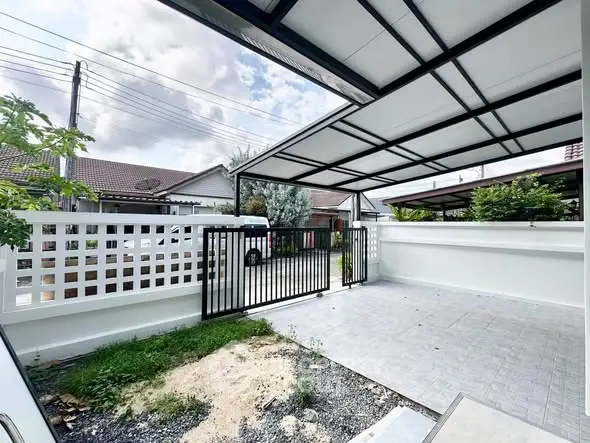 Modern residential property with spacious gated driveway and covered carport.