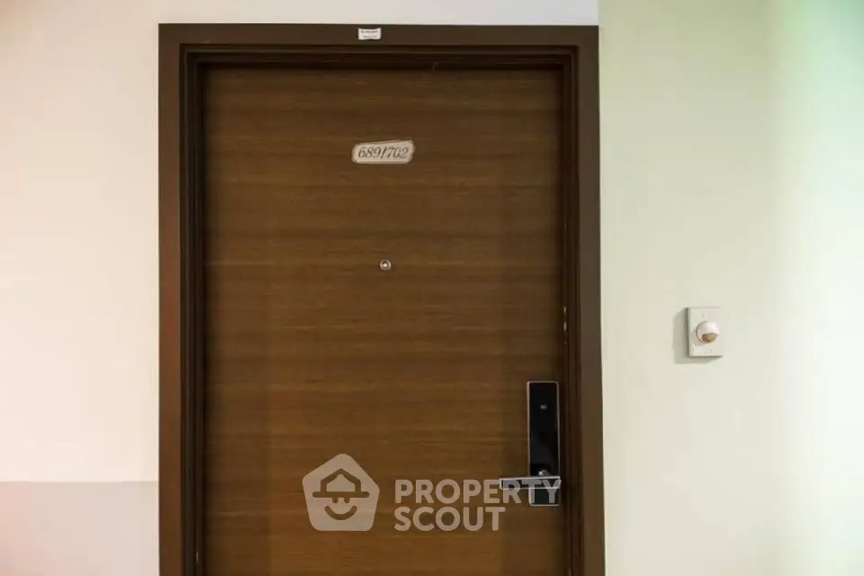 Modern apartment entrance with secure electronic lock and peephole, ideal for urban living.