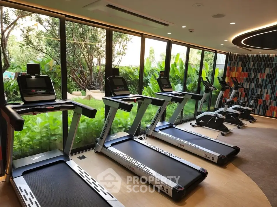 Modern gym with treadmills and lush garden view, perfect for fitness enthusiasts seeking a serene workout environment.