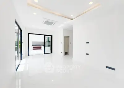 Spacious modern living room with large windows and sleek white interior design.