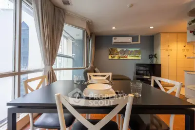Modern dining area with large windows and stylish decor in a cozy apartment.