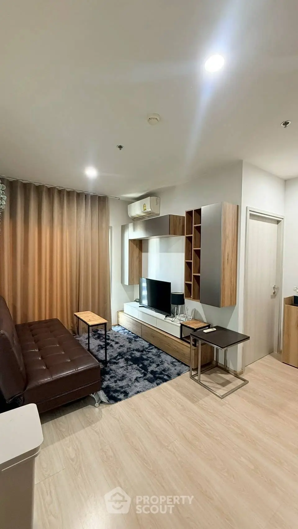 Modern living room with stylish furniture and cozy ambiance, featuring a sleek TV unit and elegant decor.