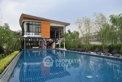 Luxurious modern house with large swimming pool and lush greenery, perfect for relaxation and entertainment.