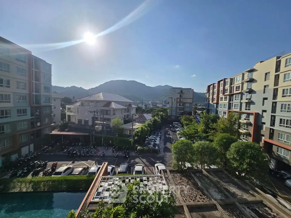 Stunning view from a modern apartment complex overlooking lush greenery and mountains.
