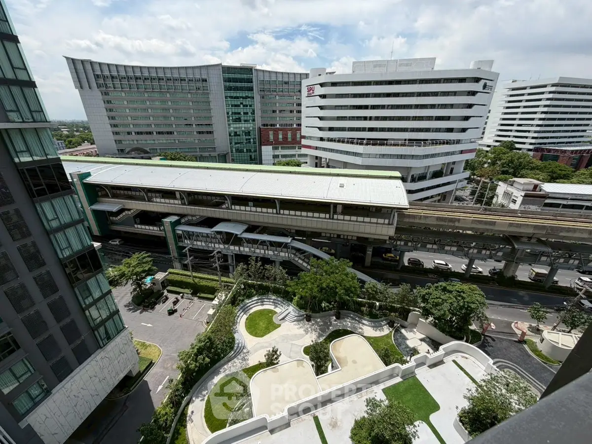Stunning cityscape view from high-rise building overlooking modern architecture and lush greenery.