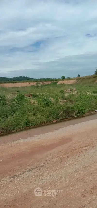 Expansive land plot with lush greenery and clear skies, ideal for development opportunities.