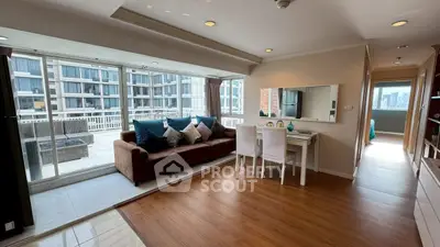 Spacious living room with large balcony and modern decor in urban apartment.