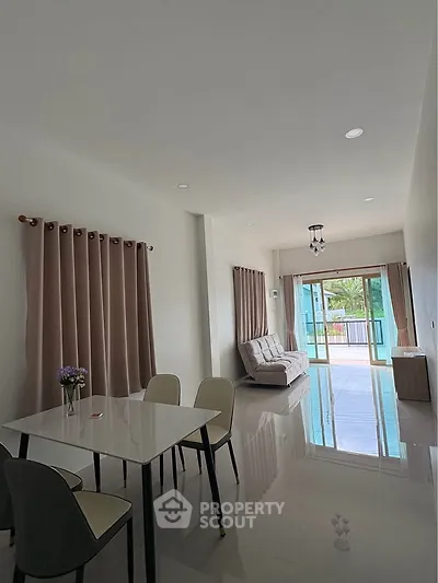 Spacious modern living room with large windows and elegant dining area