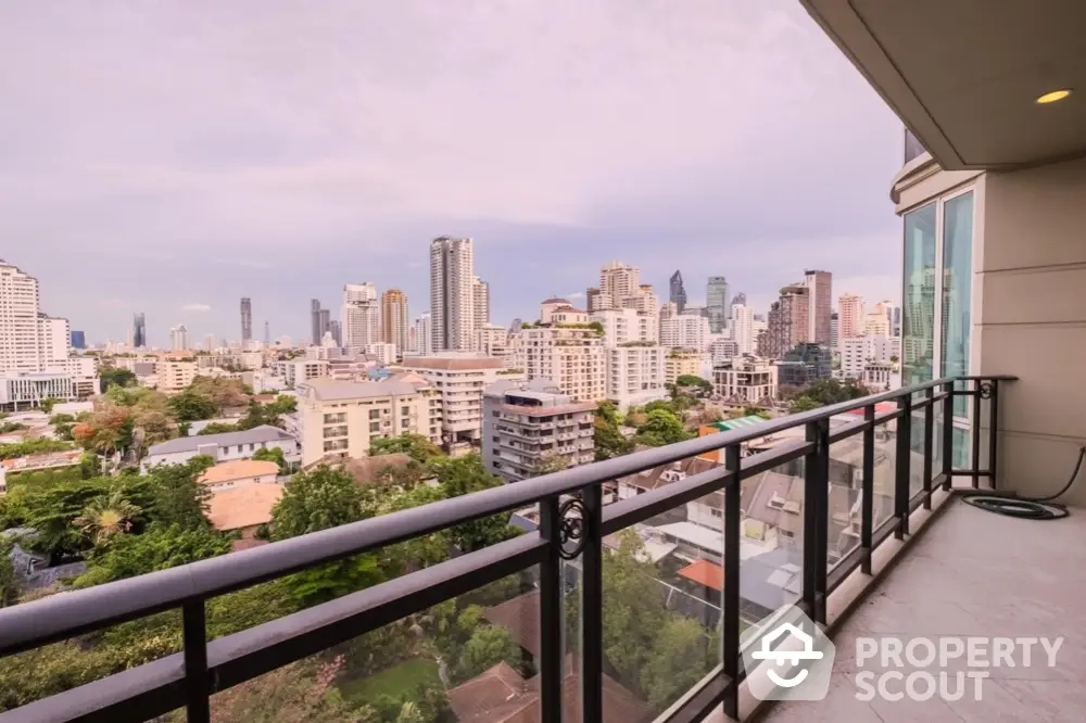 Stunning cityscape view from a modern high-rise balcony with glass railing.