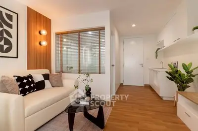 Modern living room with stylish decor and open layout, featuring a cozy sofa and elegant lighting.