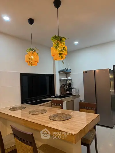 Modern kitchen with stylish pendant lights and sleek appliances, perfect for culinary enthusiasts.