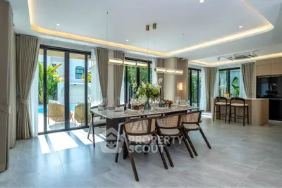 Luxurious open-plan dining area with elegant decor and pool view, perfect for entertaining guests.