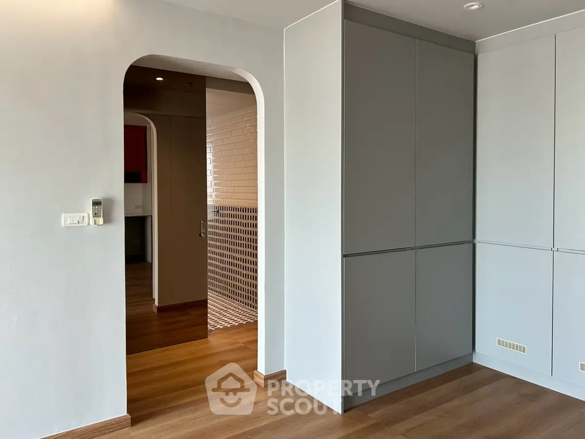 Modern interior with sleek cabinetry and wood flooring, showcasing minimalist design and open layout.