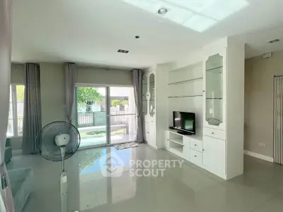 Spacious living room with modern decor and large windows overlooking garden