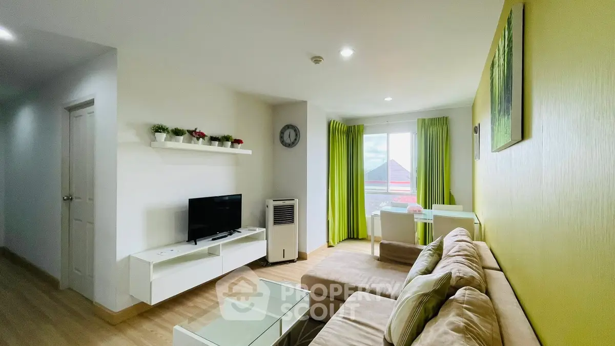 Modern living room with cozy sofa and bright decor, featuring a TV and large window with green curtains.