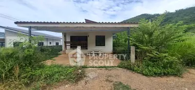 Charming single-story house with covered patio and lush greenery, perfect for serene living near nature.